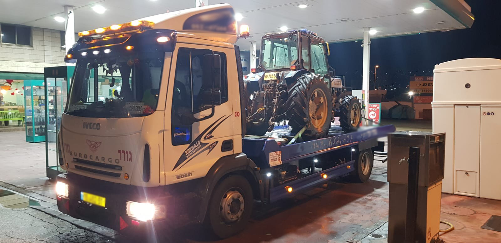 משאית גרר מובילה טרקטור בתוך מבנה