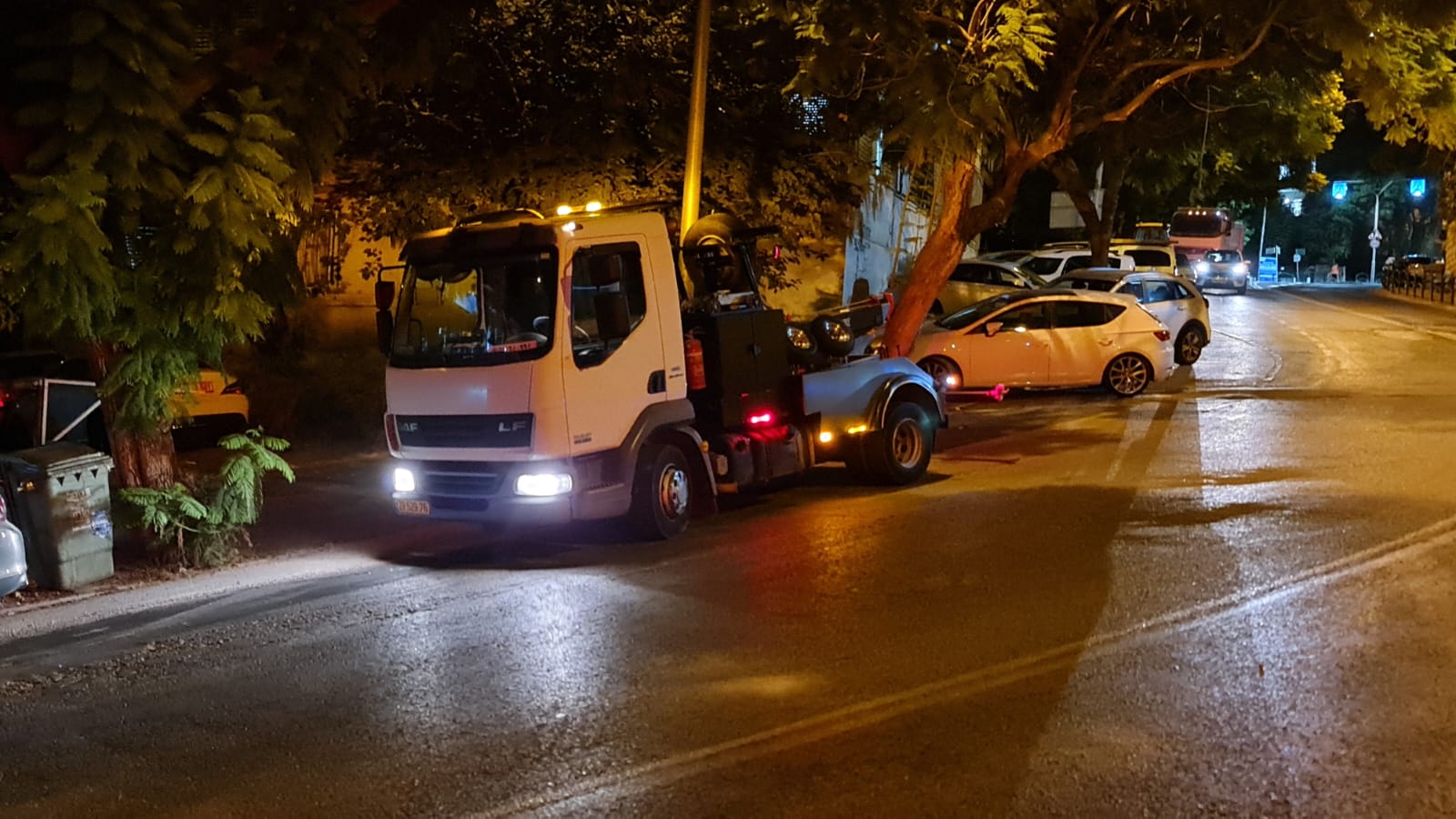 משאית גרר בפעולה ברחוב בלילה